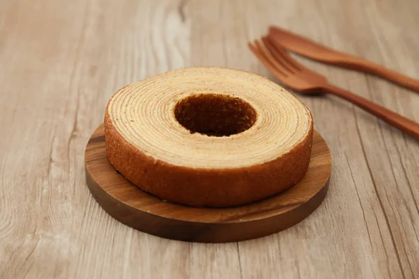 Baumkuchen Bolo de donut alemão na faca de garfo de placa de madeira na mesa — Fotografia de Stock