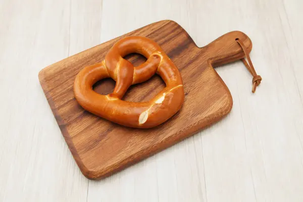 Pretzel German bread on wood plate isolated on table — Stock Photo, Image