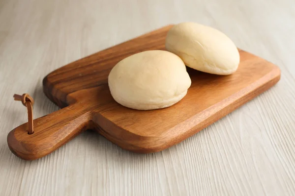 Pan blanco al horno en tabla de cortar de madera aislado en la mesa —  Fotos de Stock