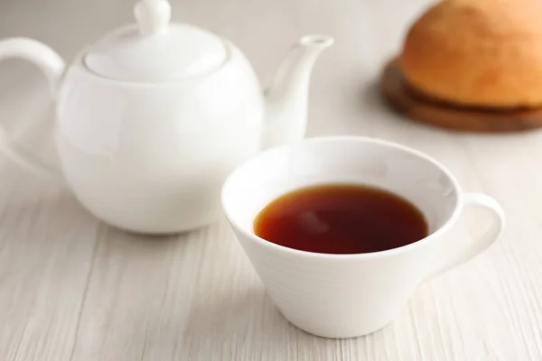 Taza de tetera de té con pan en mesa de madera aislada — Foto de Stock