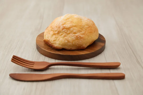 sugar bread melon pan on wood plate fork knife isolated on table