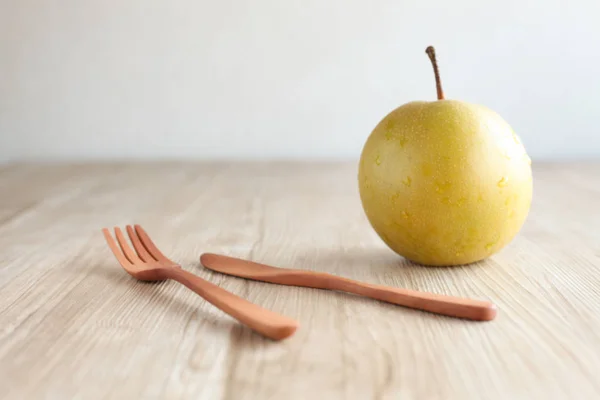 Japanese pear nashi with fork and knife isolated on table