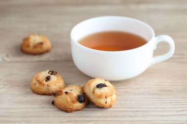 ahşap masada izole çay ve bisküvi kuru üzüm çerezleri fincan