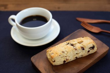ahşap masada kahve bir fincan ile kurutulmuş meyve scone bisküvi
