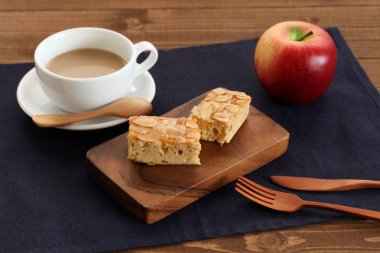 kesme tahtası ve ahşap masada sütlü kahve badem Elma Pound Kek parçası