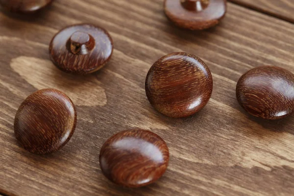 Botões de madeira marrom na mesa de madeira — Fotografia de Stock
