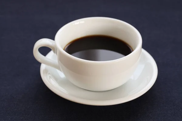 Café caliente negro sobre mesa azul marino —  Fotos de Stock