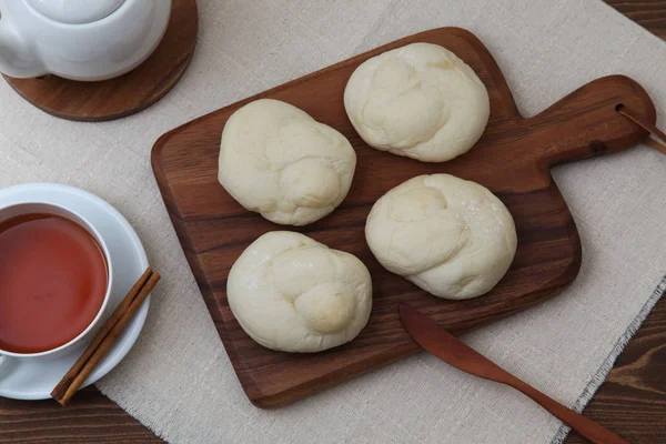Ψημένο φλιτζάνι τσάι λευκό ψωμί σε σανίδα κοπής ξύλου απομονωμένη στο τραπέζι — Φωτογραφία Αρχείου