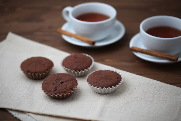 Schokoladen-Cupcakes auf Holztisch mit Teetasse — Stockfoto