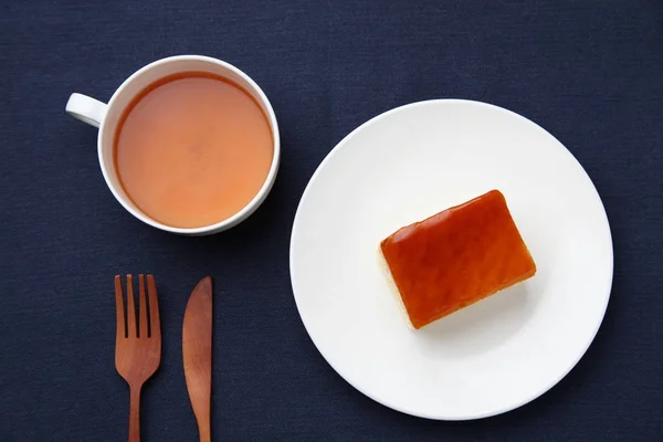 Orange honey syrup cake on plate with hot tea isolated on table — Stock Photo, Image