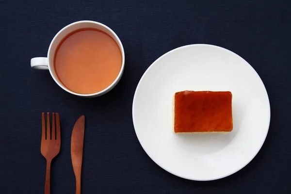 Sinaasappel honing siroop taart op plaat met hete thee geïsoleerd op tafel — Stockfoto