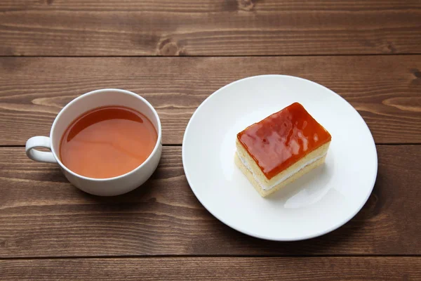 Tarta de miel de naranja en el plato con té caliente aislado en la mesa — Foto de Stock