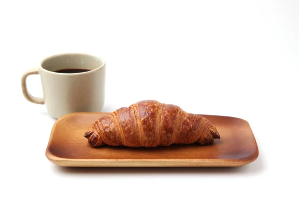 Croissant französisches Brot auf Holzteller und heißen Kaffee isoliert auf weißem Hintergrund — Stockfoto