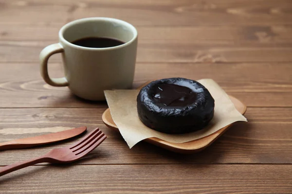 Dulce pastel de ópera de chocolate danés en placa de madera con café caliente aislado en la mesa — Foto de Stock