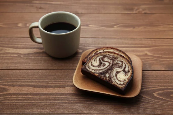 Café caliente negro y pastel de mármol de chocolate libra aislado en la mesa de madera — Foto de Stock