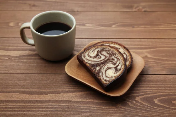 Café quente preto e bolo de libra de chocolate de mármore isolado na mesa de madeira — Fotografia de Stock