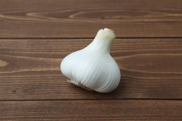 Ακατέργαστο σκόρδο απομονώνεται σε ξύλινο τραπέζι — Φωτογραφία Αρχείου