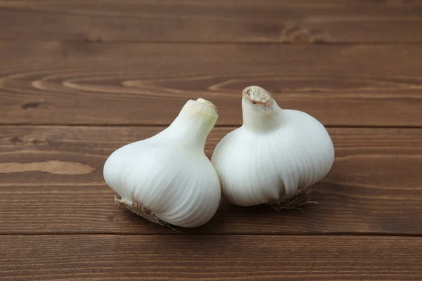 Rauwe knoflook geïsoleerd op houten tafel — Stockfoto