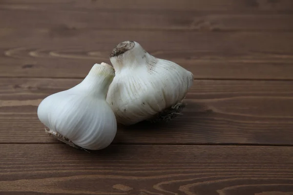 Rauwe knoflook geïsoleerd op houten tafel — Stockfoto