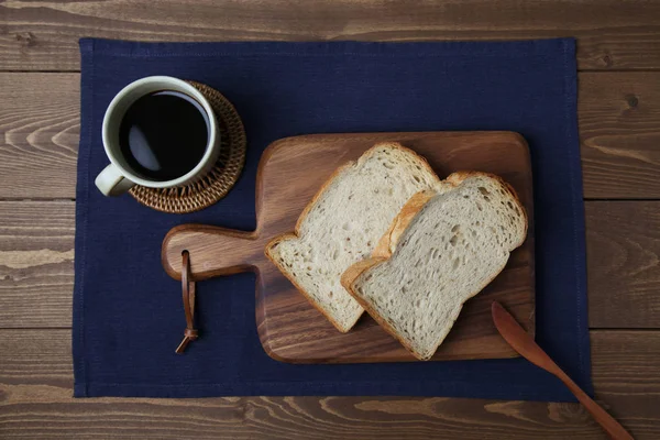 Fatias torradas de pão com nozes na tábua de corte de madeira na mesa — Fotografia de Stock