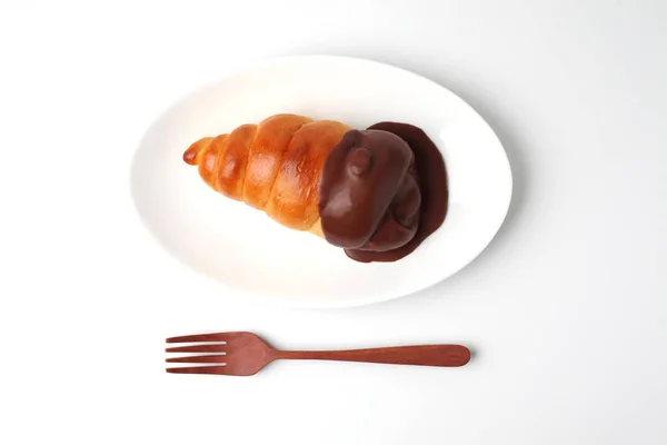 Pão de rolo de corneto de chocolate na placa isolada no fundo branco — Fotografia de Stock