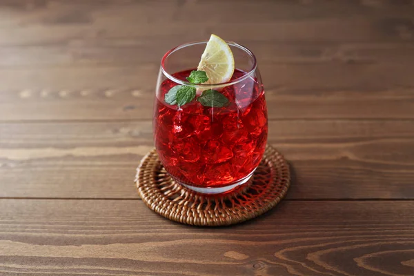 Ποτήρι κρύο τσάι κόκκινο ποτό απομονώνεται σε ξύλινο τραπέζι — Φωτογραφία Αρχείου