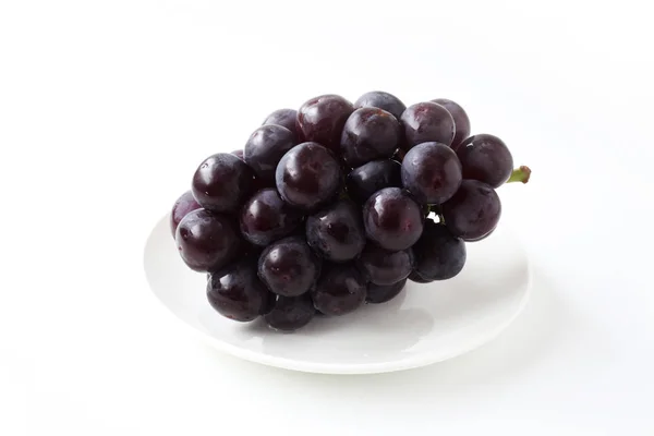 Свежий гроздь винограда на тарелке изолированы на белом фоне — стоковое фото