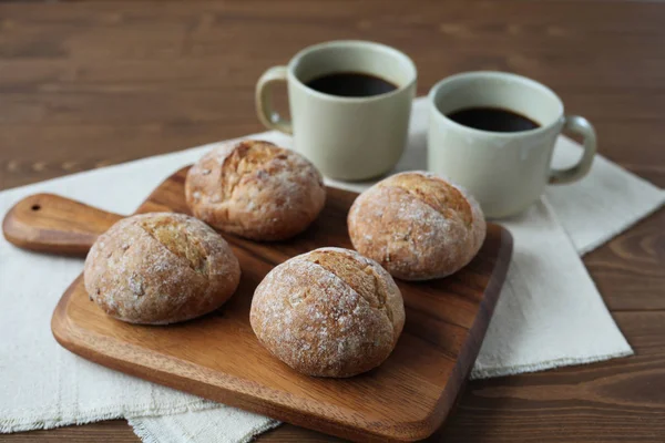 French rye bread with cups of coffee on wooden table — Stock Photo, Image