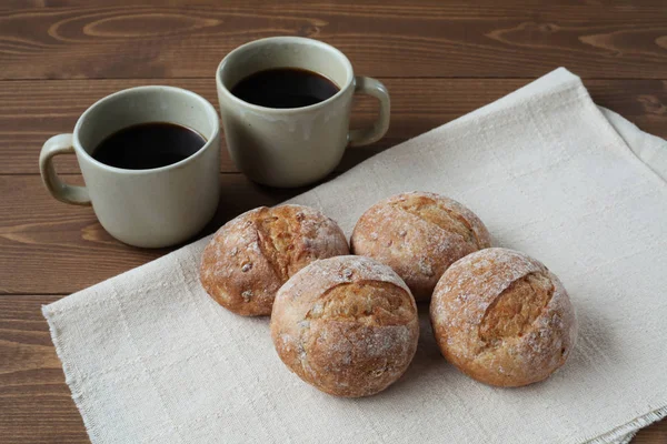 French rye bread with cups of coffee on wooden table — Stock Photo, Image