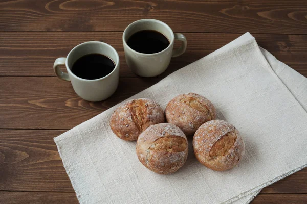 Pão de centeio francês com xícaras de café na mesa de madeira — Fotografia de Stock