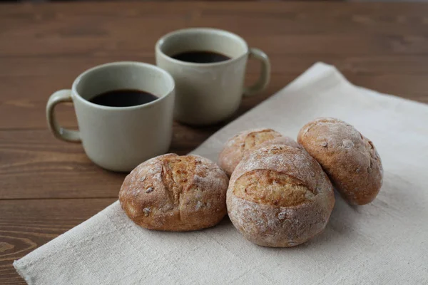 French rye bread with cups of coffee on wooden table — Stock Photo, Image