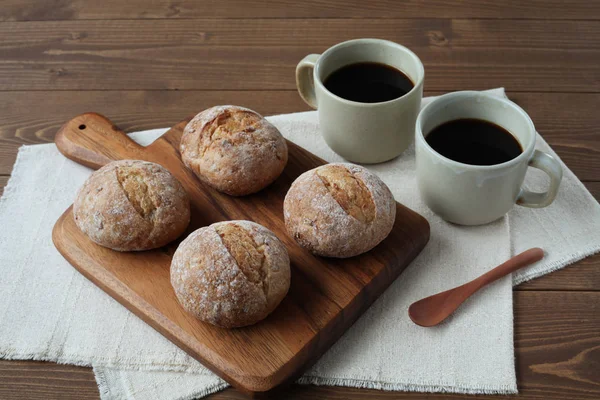 French rye bread with cups of coffee on wooden table — Stock Photo, Image