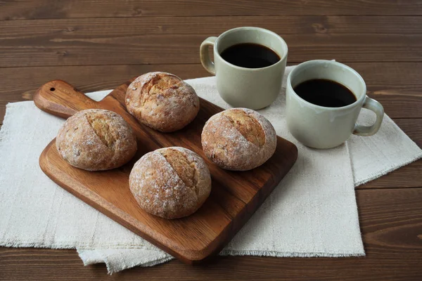 French rye bread with cups of coffee on wooden table — Stock Photo, Image