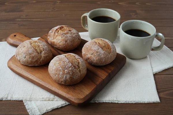 French rye bread with cups of coffee on wooden table — Stock Photo, Image