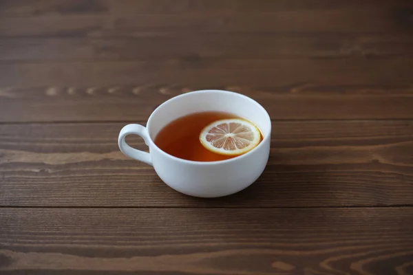 Taza de té con limón en rodajas primer plano aislado en la mesa de madera — Foto de Stock