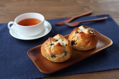 ahşap masada izole İngiliz çayı closeup ile kuru üzüm ekmek