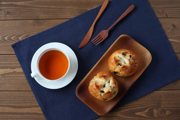 Pan de pasas con té inglés aislado en mesa de madera — Foto de Stock
