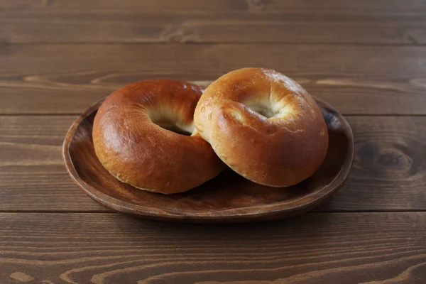 Lapos bagels kenyér, fa tányéron az asztalon — Stock Fotó