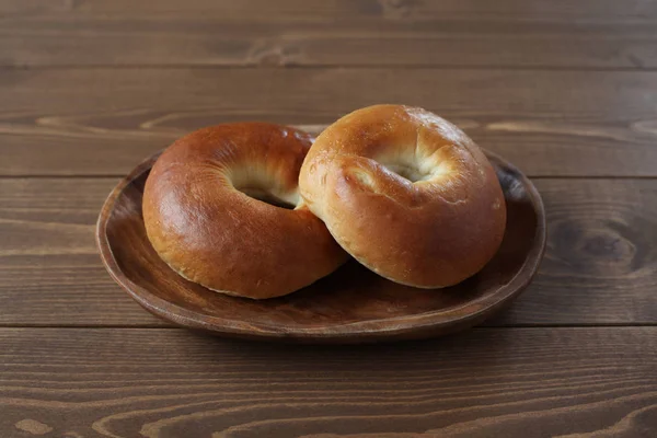 Obyčejný bagely chléb na dřevěné desce na stole — Stock fotografie