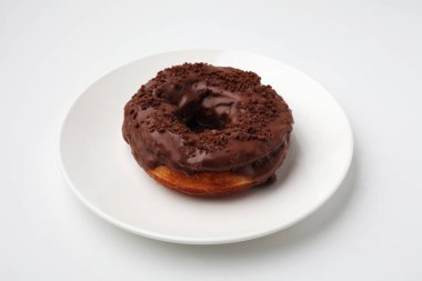 beyaz arka plan üzerinde izole plaka üzerinde çikolata buzlu çörek