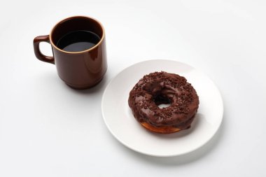 beyaz arka plan üzerinde izole sıcak kahve ile tabakta çikolata buzlu çörek