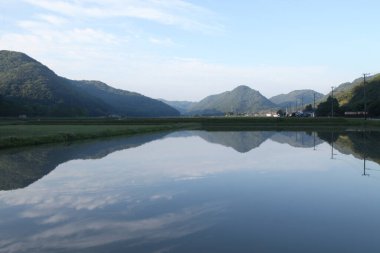 pirinç tarlasının su aynasındaki dağlar ve gökyüzü