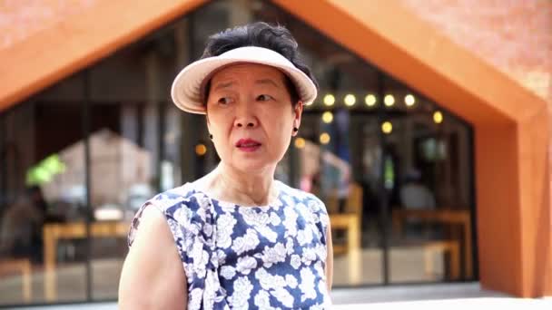 アウトレットでのショッピングの帽子をかぶってアジア上級中国人観光客 — ストック動画