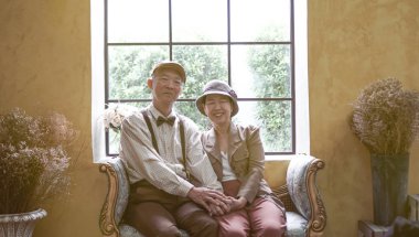 Asian senior couple dress vintage retro style in luxury house with tuscan style yellow wall clipart