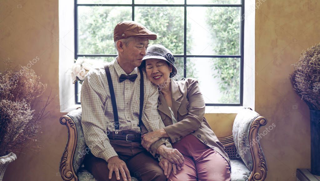 Asian senior couple dress vintage retro style in luxury house with tuscan style yellow wall