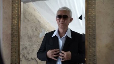 Zengin Asya kıdemli ayna önce iş toplantı ile takım elbise Giydir