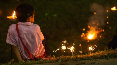 Chaing Mai, Tayland, 15 Nisan 2015-çocuk oturmak ve nehir yanında havai fişek oynamak