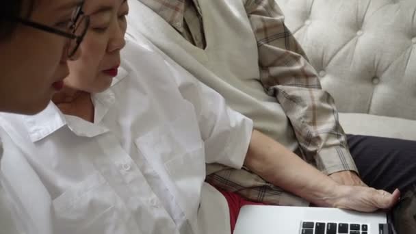 亚洲资深夫妇用电脑手提电脑提供健康医疗建议 — 图库视频影像