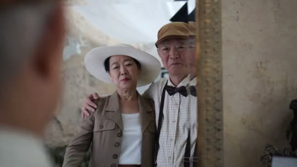 亚洲资深夫妇互相帮助在镜子录影前面穿戴复古样式 — 图库视频影像