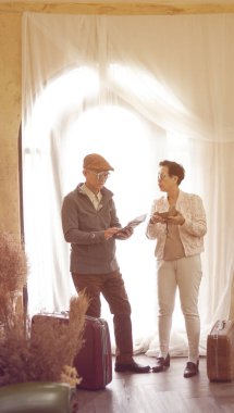 Asya kıdemli çift akıllı telefon teknoloji seyahat sırasında bavul ile kullanın.